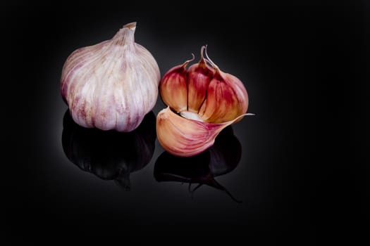 Garlic with reflection on black background.