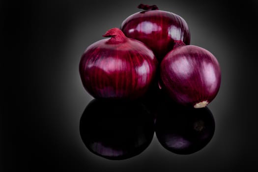 Shallots on black background with reflect onion bulb.