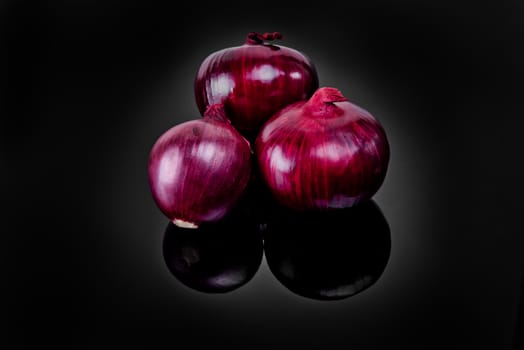 Shallots on black background with reflect onion bulb.