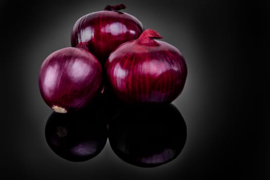 Shallots on black background with reflect onion bulb.