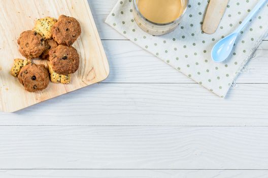 Chocolate Chip Cookies on wood block and white wood table and drinking with coffee and bread in dessert time.