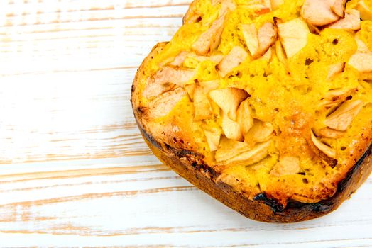 Fresh bakery. Baked pie with apples on white wooden background.