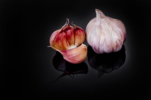 Garlic with reflection on black background.