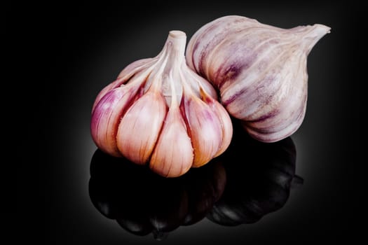 Fresh garlic bulbs on a black background.