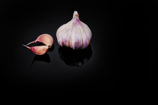 Garlic with reflection on black background.