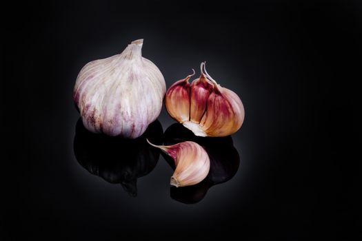 Garlic with reflection on black background.