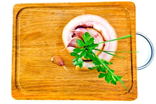 Pork belly with garlic and parsley on wooden board isolated on a white background.