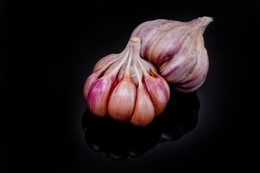 Fresh garlic bulbs on a black background.