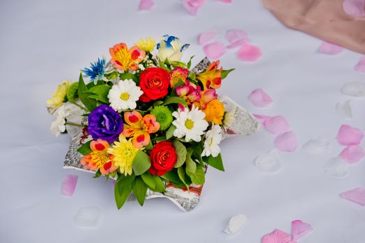 A beautiful gift bouquet in a wooden vase on a wooden bench. Wedding decorations.