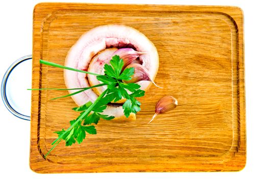 Pork belly with garlic and parsley on wooden board isolated on a white background.