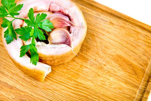 Pork belly with garlic and parsley on wooden board isolated on a white background.