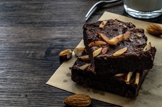 Chocolate Brownie with Almonds on the wood table has ready to served in the dessert time.