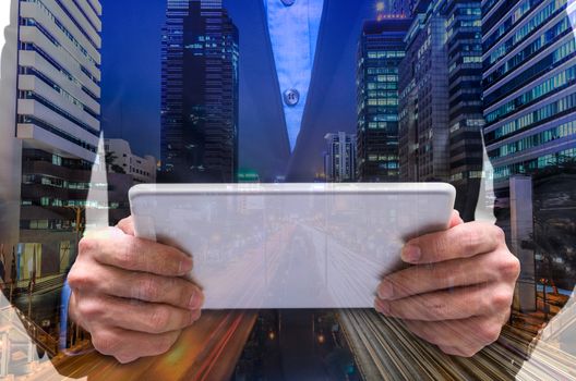 Double exposure of businessman using tablet with long exposure city.