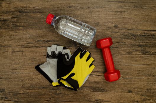 Red Dumbbell, Yellow Groove and Water Bottle on the wooden table background has preparing to fitness and exercise for diet time.