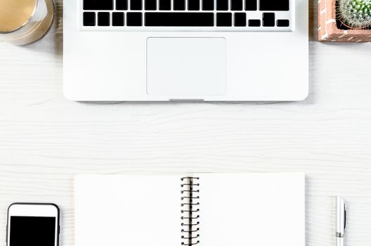 White wood office desk table with a lot of equipment for working in top view and copy space.