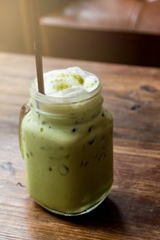Homemade ice green tea matcha smoothies on wood table in the morning with relaxing and break time.