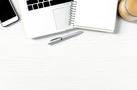 White wood office desk table with a lot of equipment for working in top view and copy space.