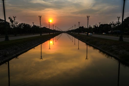 Sunset over a highway Utthayan Road and reflection on the river in Bangkok Thailand.