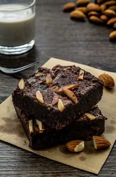 Chocolate Brownie with Almonds on the wood table has ready to served in the dessert time.