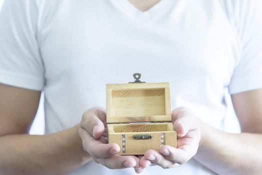 Man has give a surprise present with empty wooden treasure. Selective focus and isolated and white background concept.