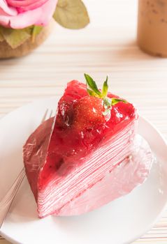 Strawberry crape cake in white plate with closeup view on wooden and ready to served in the morning.