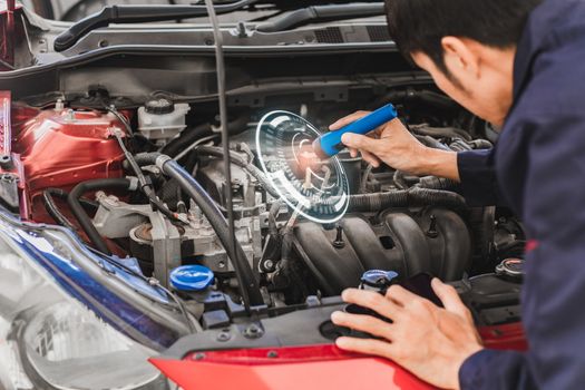 Asian Man mechanic inspection Shine a torch car engine checking bug in engine from application smartphone.Red car for service maintenance insurance with car engine.for transport automobile automotive