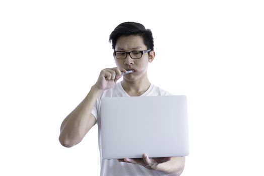 Asian handsome man with white shirt has wake up and  sleepy with tooth brush and working by holding laptop before going to start the work in the morning isolated on white background and clipping paths.