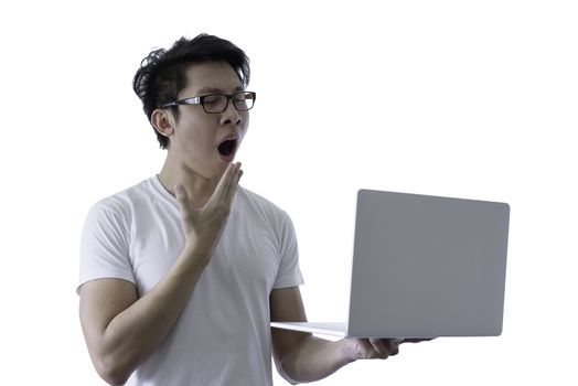 Asian handsome man with white shirt has wake up with sleepy and holding computer laptop for working with lazy and bored before going to start the work in the morning isolated on white background and clipping paths.