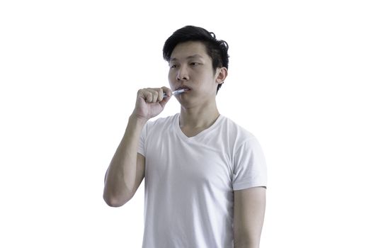 Asian handsome man with white shirt has wake up and  sleepy with tooth brush before going to start the work in the morning isolated on white background and clipping paths.