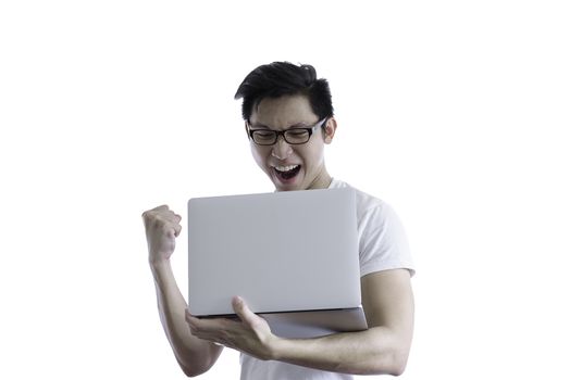 Asian handsome man with white shirt and orange eyeglasses has happy and feeling like a winner when holding and working with computer laptop for goal and successful isolated on white background and clipping paths.