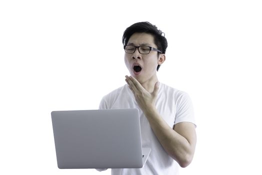 Asian handsome man with white shirt has wake up with sleepy and holding computer laptop for working with lazy and bored before going to start the work in the morning isolated on white background and clipping paths.