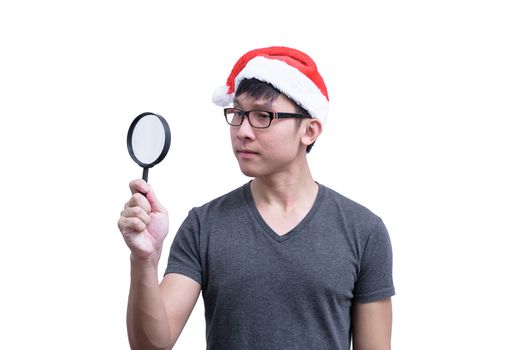 Asian Santa Claus man with eyeglasses and grey shirt has searching something with magnifying glass isolated on white background with copy space.