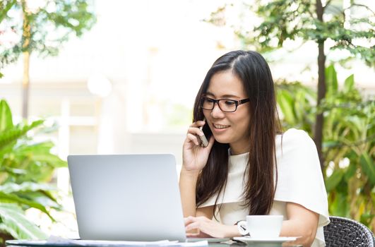 Beautiful asian attractive woman has working and talking with phone for business marketing at coffee cafe in the morning with happy and relaxing time.