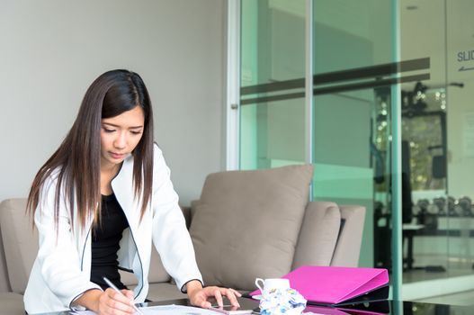 Women working and looking a computer with intention and seriously in the office interior.