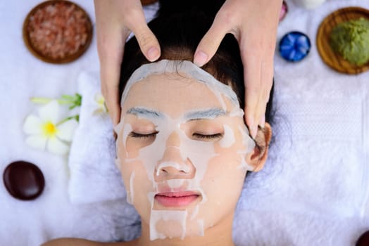 Portrait of beautiful asian people has masking with close up view and close up eyes and having hand massage in spa salon. Beauty, healthy, spa and relaxation concept.