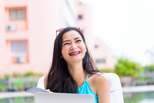 Sexy asian woman has working with laptop in the evening and sunset time with relaxing on vacation and holiday.