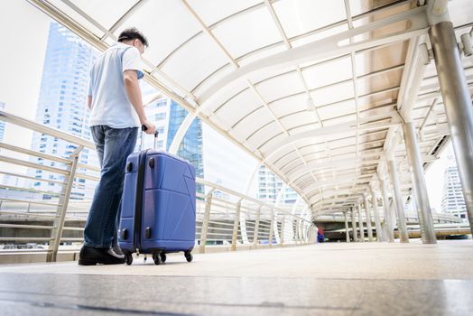 Asian adult tourist walking and travel with big blue bag to travel.