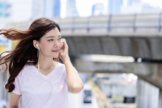 Asian beautiful woman tourist has music listening with headphone and happiness to travel.