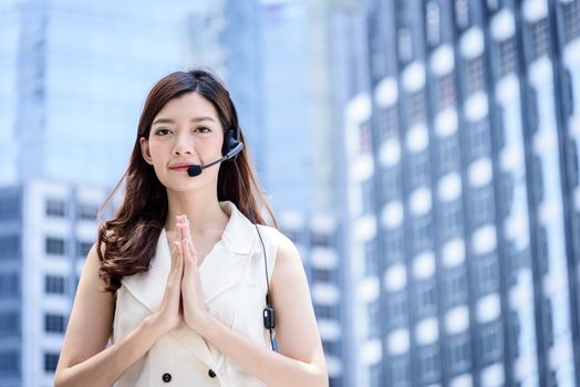 Thai asian business woman making hello with thai culture style with building and city background.