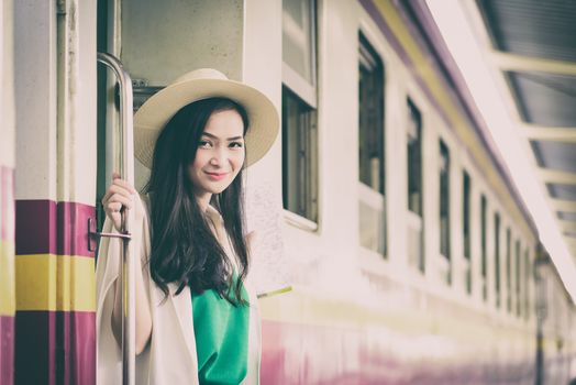 Asian woman traveler has get in the train with happiness at Hua Lamphong station at Bangkok, Thailand.