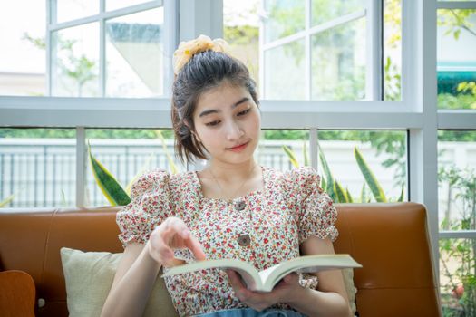 Asian women reading a book in the garden at home on a relaxing time