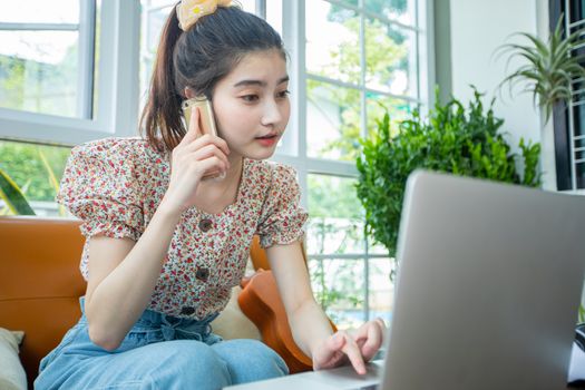 Asian businesswomen are using notebook computers and using a mobile phone for online meetings and working from home