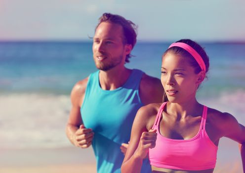 Couple athletes runners running on beach. Interracial young adults asian woman, caucasian man, training cardio together doing outdoor workout jogging. Photo filtered, pink color filter.