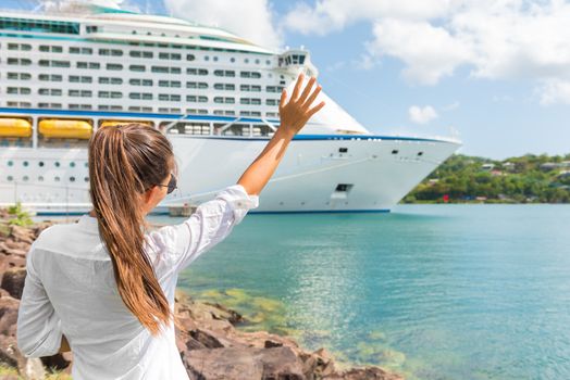 Happy joyful woman waving hello or goodbye hand sign to cruise ship. Caribbean luxury travel vacation concept. Boat leaving harbor, tourist people greeting.