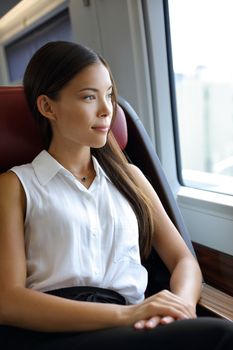 Beautiful Asian young professional woman enjoying view on travel commute. Business class by train. Businesswoman relaxing in luxury high end seat in transport.