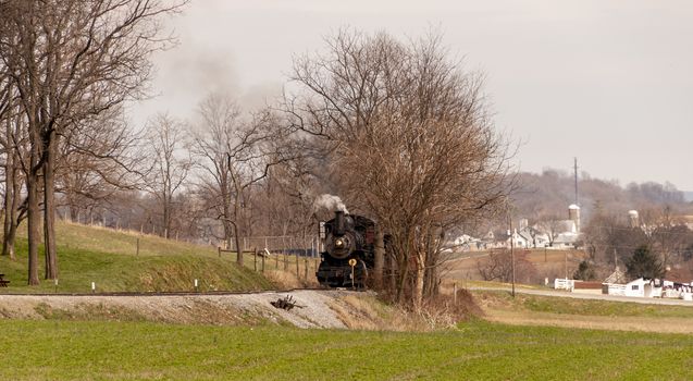 An old train in the middle of leafless trees