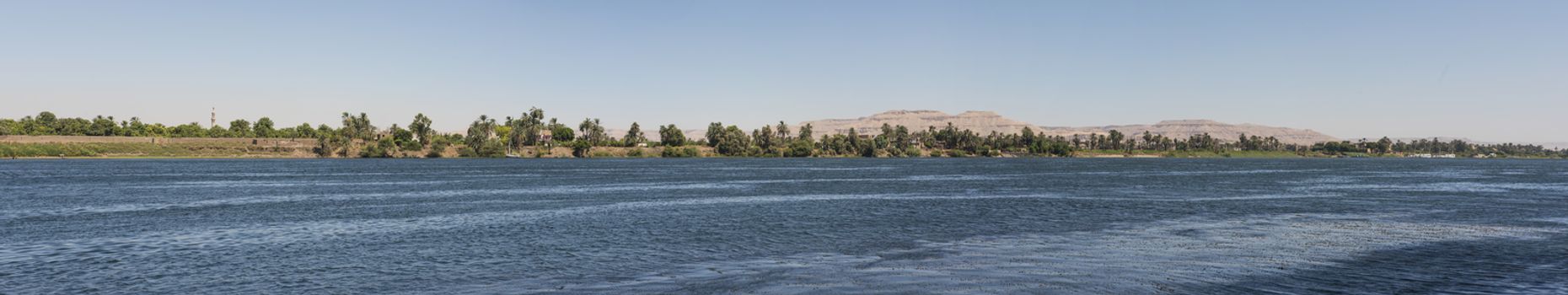 Panoramic landscape rural countryside view of large river nile in arid environment showing luxor west bank