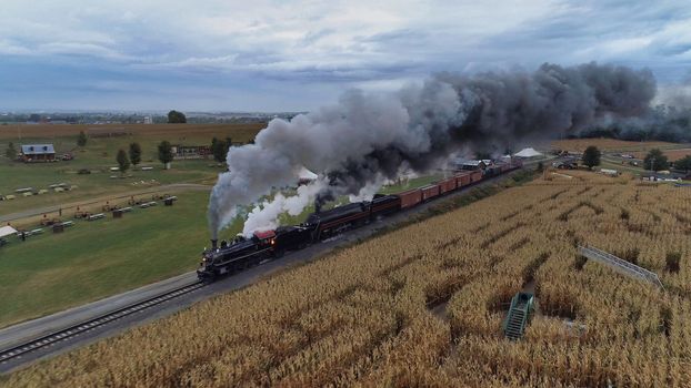A high angle shot of an old train with smoke coming out of is chimney