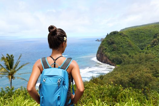 Hawaii travel nature hiker girl hiking in Pololu valley enjoying lookout view of mountains. Big island destination, woman tourist in Hawaii, USA.