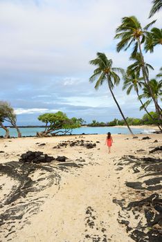 Hawaii beach vacation woman walking on secluded white sand beach on Big island of Hawaii, USA travel.